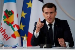 FILE - French President Emmanuel Macron gestures as he delivers a speech after a meeting via video-conference with leaders of West African G-5 Sahel nations, in Paris, France, Feb. 16, 2021.