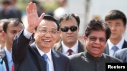 PM China Li Keqiang melambaikan tangan kepada para wartawan setibanya di New Delhi, India (19/5).