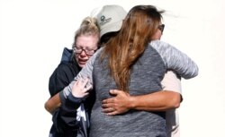 FILE - Mourners react outside a reception center for families of victims of a mass shooting in Thousand Oaks, Calif., Nov. 8, 2018.