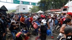 Para migran mencoba melintasi perbatasan dari Corinto, Honduras, ke Corinto, Guatemala, 1 Oktober 2020. (Foto: AP)