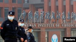 当世卫组织新冠病毒源头调查组视察武汉的中国科学院病毒研究所期间，中国保安人员在研究所外站岗。 （2021年2月3日）