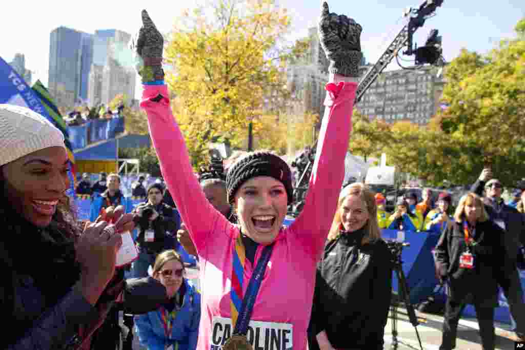 La joueuse de tennis Caroline Wozniacki lève les mains quand il reçoit la médaille pour avoir affranchi la ligne d’arrivée du marathon de la ville New York, le 2 novembre.