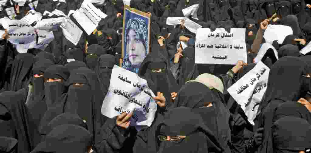 January 2011: Yemeni women hold placards and a photograph of activist Tawakkul Karman during an anti-government rally in Sanaa. Placards read in Arabic, "Arresting Karman is an unethical incident against Yemeni Women."