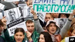 Para pengunjuk rasa membawa foto-foto para demonstran yang ditahan dan poster bertuliskan slogan-slogan "Beri kami hak untuk memilih" dalam unjuk rasa di Moskow, Rusia, 10 Agustus 2019. (Foto: AP)