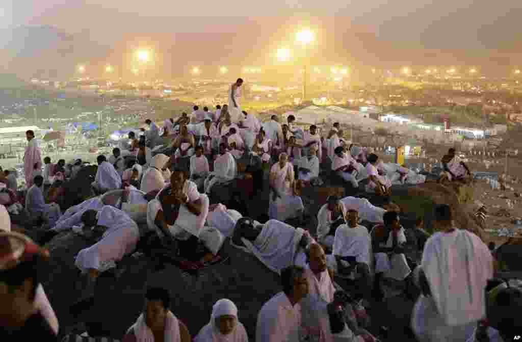 Muslim pilgrims pray on a rocky hill called the Mountain of Mercy, on the Plain of Arafat near the holy city of Mecca, Saudi Arabia, in the early hours of October 25, 2012.