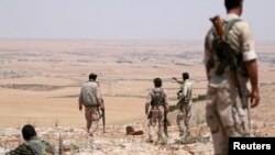 Fighters of the Manbij military council, take an overwatch position in the southern rural area of Manbij, Syria, June 1, 2016. 