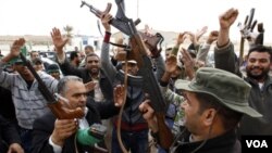 Pendukung Gaddafi menyerukan slogan merayakan perebutan kembali sebuah kantor polisi di Bin Jawad, Sabtu (12/3).