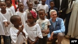 Le Haut Commissariat des Nations Unies pour les réfugiés, Filippo Grandi, pose avec un groupe d'enfants réfugiés à Agadez le 21 juin 2018.