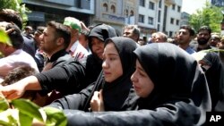 FILE - Iranians attend the funeral of victims of an Islamic State militant attack, in Tehran, Iran, June 9, 2017. Attacks claimed by Islamic State killed 17 people. 