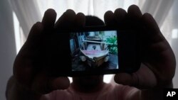 En esta foto del martes 21 de junio de 2022 en North Miami Beach, Florida, un migrante cubano que pidió no ser identificado por temores a la seguridad de su familia que vive en la isla, muestra una foto del bote rudimentario que fabricó para salir de Cuba junto a tres amigos.