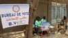 Les travailleurs électoraux s'assoient à côté d'une urne dans un bureau de vote lors de l'élection présidentielle à N'djamena, au Tchad, le 6 mai 2024.