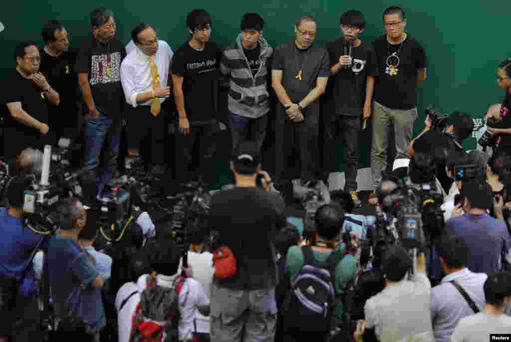 Joshua Wong, second right, leader of the student movement, talks to the media as protesters block areas around the government headquarters office in Hong Kong, Oct. 9, 2014.