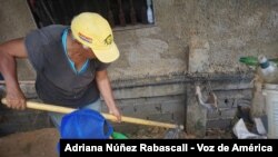 Una mujer trabaja la tierra junto a su nieto a las afueras de Caracas, Venezuela.