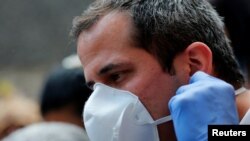 Juan Guaidó, se quita el tapabocas antes de hablar en una conferencia de prensa. Junio, 17, 2020.