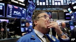 Trader Steven Kaplan works on the floor of the New York Stock Exchange, Tuesday, June 19, 2018. U.S. stock markets are opening sharply lower Tuesday as tensions over trade between the U.S. and China increase. (AP Photo/Richard Drew)