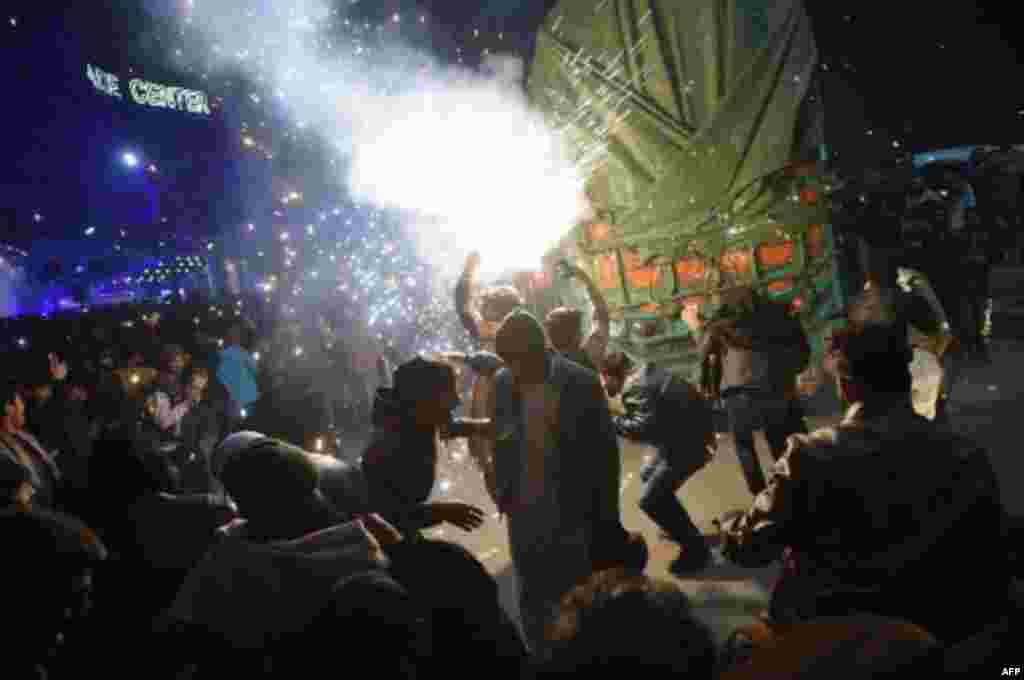 Los jóvenes paquistaníes disfrutan de la exhibición de fuegos artificiales durante las celebraciones de Año Nuevo en Rawalpindi.