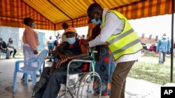 FILE - A Kenyan man receives a dose of the AstraZeneca coronavirus vaccine donated by Britain, at the Makongeni Estate in Nairobi, Kenya, Aug. 14, 2021.