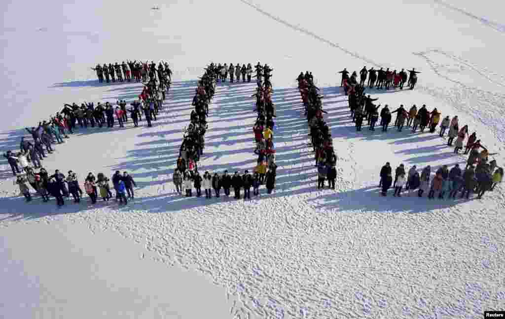 Students form "2015" standing on snow to welcome the upcoming New Year at Shenyang Agriculture University in Shenyang, Liaoning province, China, Dec. 31, 2014.