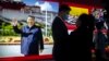People gather near a display featuring a photo of Chinese President Xi Jinping at the Potala Palace in Beijing, Oct. 20, 2021.