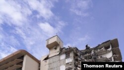 امدادگران در محل ساختمان فروریخته در سرف‌ساید، فلوریدا، در تصویری که خبرگزاری رویترز از رسانه‌ای اجتماعی به دست آورده است.