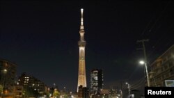El Tokyo Skytree se ilumina con el color de la antorcha olímpica que recorrerá las calles de Japón a cuatro meses de la retrasada cita de los Juegos Olímpicos, debido a la pandemia de coronavirus.