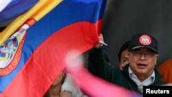 ARCHIVO: El presidente de Colombia, Gustavo Petro, ondea una bandera mientras la gente asiste a una marcha en apoyo de las reformas en los sectores de salud, jubilación, empleo y prisiones propuestas por su gobierno, en Bogotá, Colombia, el 1 de mayo de 2024.