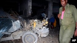 Un policier marche près du lieu d'une explosion d'un véhicuke piégé à Mogadiscio, Somalie.