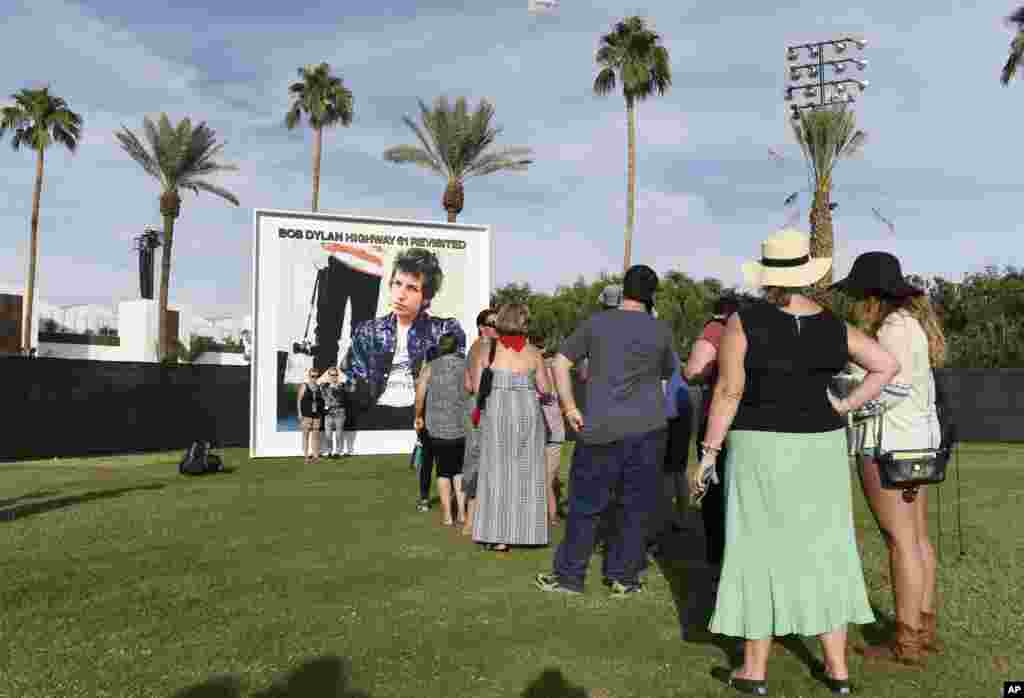 Pengunjung antre untuk berfoto di papan reklame album Bob Dylan "Highway 61 Revisited" pada hari pertama festival musik Desert Trip 2016 di Empire Polo Field di Indio, California (7/10).