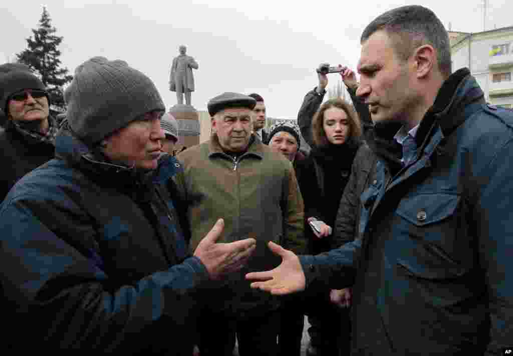 Ukrainian lawmaker and chairman of the Ukrainian party Udar (Punch), former WBC heavyweight boxing champion Vitali Klitschko, right, speaks with locals in Donetsk, Ukraine, March 9, 2014. 