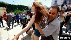 La police arrêtant un membre du FEMEN lors d'une manifestation