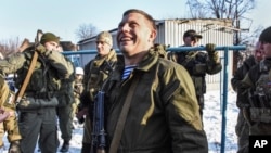Pro-Russian rebel leader Alexander Zakharchenko, center, surrounded by guards, smiles not far from rebel positions near the Donetsk airport in Donetsk, Eastern Ukraine, Jan. 15, 2015.