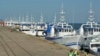 Patrulha de segurança passa por barcos da EMATUM na doca de Maputo.
