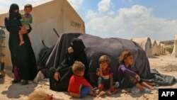 FILE - Displaced Syrians are seen at a camp near the border crossing with Turkey in the northern part of Syria's rebel-held Idlib province, Sept. 6, 2018.