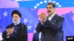 Los presidentes de Irán y Venezuela, Ebrahim Raise (izquierda) y Nicolás Maduro, participan en un acto oficial en el teatro Teresa Carreño de Caracas, el 13 de junio de 2023, en esta fotografía divulgada por el Palacio de Miraflores.