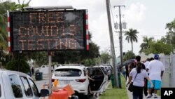 ARCHIVO - Las personas hacen fila para para realizarse las pruebas de coronavirus en Opa-locka, estado de Florida en junio de 2019.