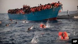 Des migrants, ressortissants d’Erythrée pour la plupart, sautent dans l’eau d’un bateau bondé lors d’une opération de sauvetage en pleine Méditerranée, à Sabratha, Libye, 29 août 2016.