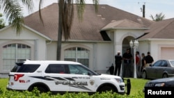 Polisi berjaga-jaga di depan salah satu rumah yang diduga terkait dengan penembak Orlando di Port St. Lucie, Florida (12/6). (Reuters/Joe Skipper)