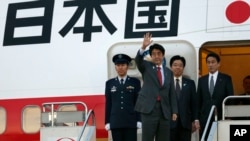 日本首相安倍在启程访美前向送行者挥手致意
