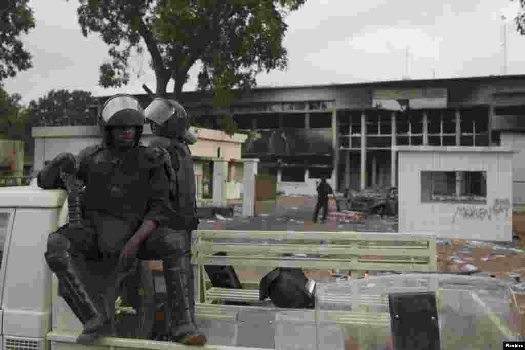 Des policiers montent la garde devant l’entrée de l’immeuble du parlement incendié à Ouagadougou, Burkina Faso.