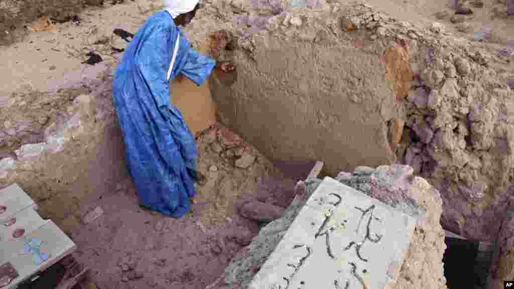 Le chef de maçon Alassane Ramiya examine une tombe après l'attaque à Tombouctou, au Mali, le 4 avril 2014.