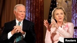 លោកស្រី Hillary Clinton អង្គុយ​នៅ​ក្បែរ​លោក James Baker ក្នុង​កិច្ចសន្ទនា​ស្តី​ពី​ការ​ទូត​នៅ​ក្រសួង​ការបរទេស​ក្នុង​រដ្ឋធានី​វ់ាស៊ីនតោន កាលពី​ថ្ងៃទិ២០ ខែមិថុនា ឆ្នាំ២០១២។
