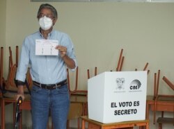 El candidato presidencial Guillermo Lasso muestra su papeleta antes de emitir su voto en la segunda vuelta de las elecciones presidenciales en un colegio electoral, en Guayaquil, Ecuador, el 11 de abril de 2021.