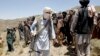 FILE - Members of a Taliban breakaway faction walk during a gathering, in Shindand district of Herat province, Afghanistan, May 27, 2016.