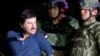 En esta foto de archivo del 8 de enero de 2016, Joaquín "El Chapo" Guzmán esposado se enfrenta a la prensa mientras es escoltado a un helicóptero por soldados e infantes de marina mexicanos en un hangar federal en la Ciudad de México.