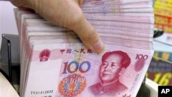 Penghitungan mata uang yuan di sebuah tempat pertukaran mata uang di Hong Kong.