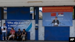 FILE - Workers rest near billboard showing Chinese President Xi Jinping, reading: "Welcome President", right, and billboard reading: "Nobody was hurt in my shift today" in front of the Zelezara Smederevo steel mill, in the city of Smederevo, 45 kilometers east of Belgrade, Serbia, June 29, 2017. When U.S. Steel sold its loss-making smelter in Serbia to the government for $1 in 2012, few thought the communist-era factory would ever be revived. 