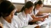FILE - Students read first-ever Cambodian-authored Khmer Rouge history textbook during its delivery to high school students in Phnom Penh, Cambodia, Oct. 10, 2009.