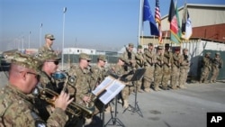 The International Security Assistance Forces band plays during flag-lowering ceremony in Kabul as NATO forces ceremonially end their 13 year combat mission in Afghanistan, Dec. 8, 2014.