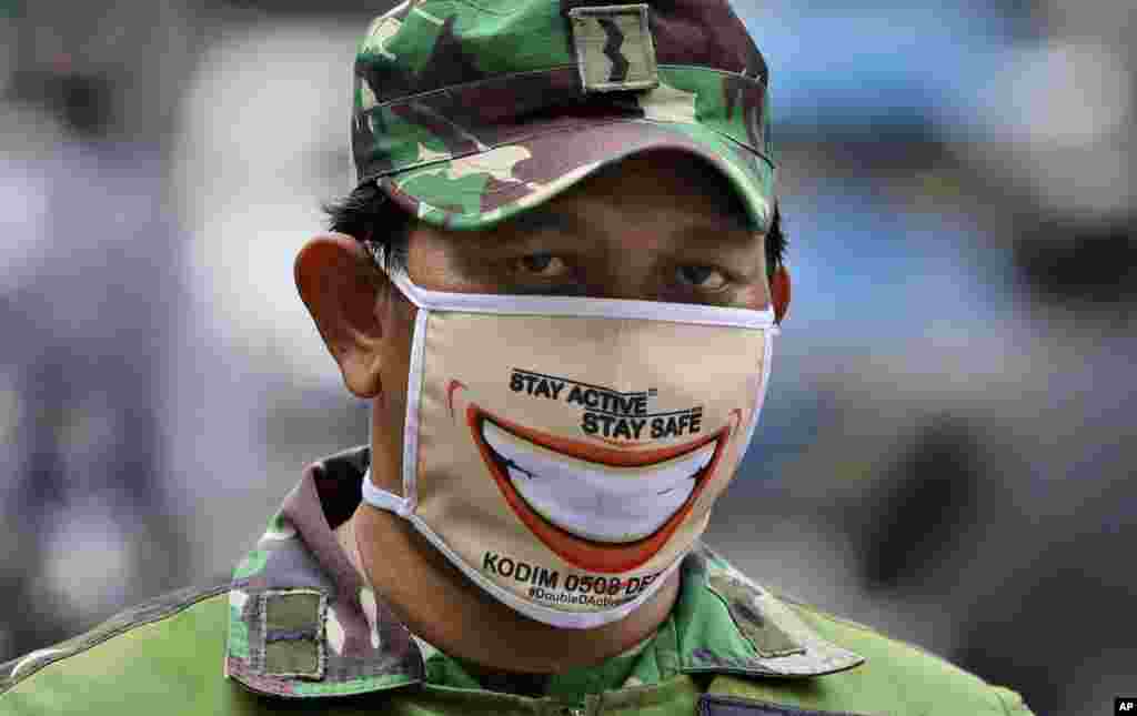 Indonesia: Un soldado usa una curiosa máscara mientras hace guardia en un puesto de control. El gobierno ha impuesto una cuarentena masiva con el objetivo de frenar la propagación del brote de coronavirus en Yakarta. La capital de Indonesia inició duras restricciones ya que el área metropolitana se ha convertido en el epicentro de coronavirus de Indonesia.