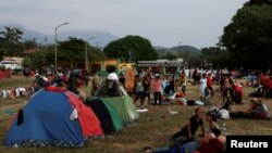 ARCHIVO: Migrantes en una caravana que viaja por México hacia la frontera con EEUU descansan en una plaza pública de Mapastepec, el 29 de diciembre de 2023.